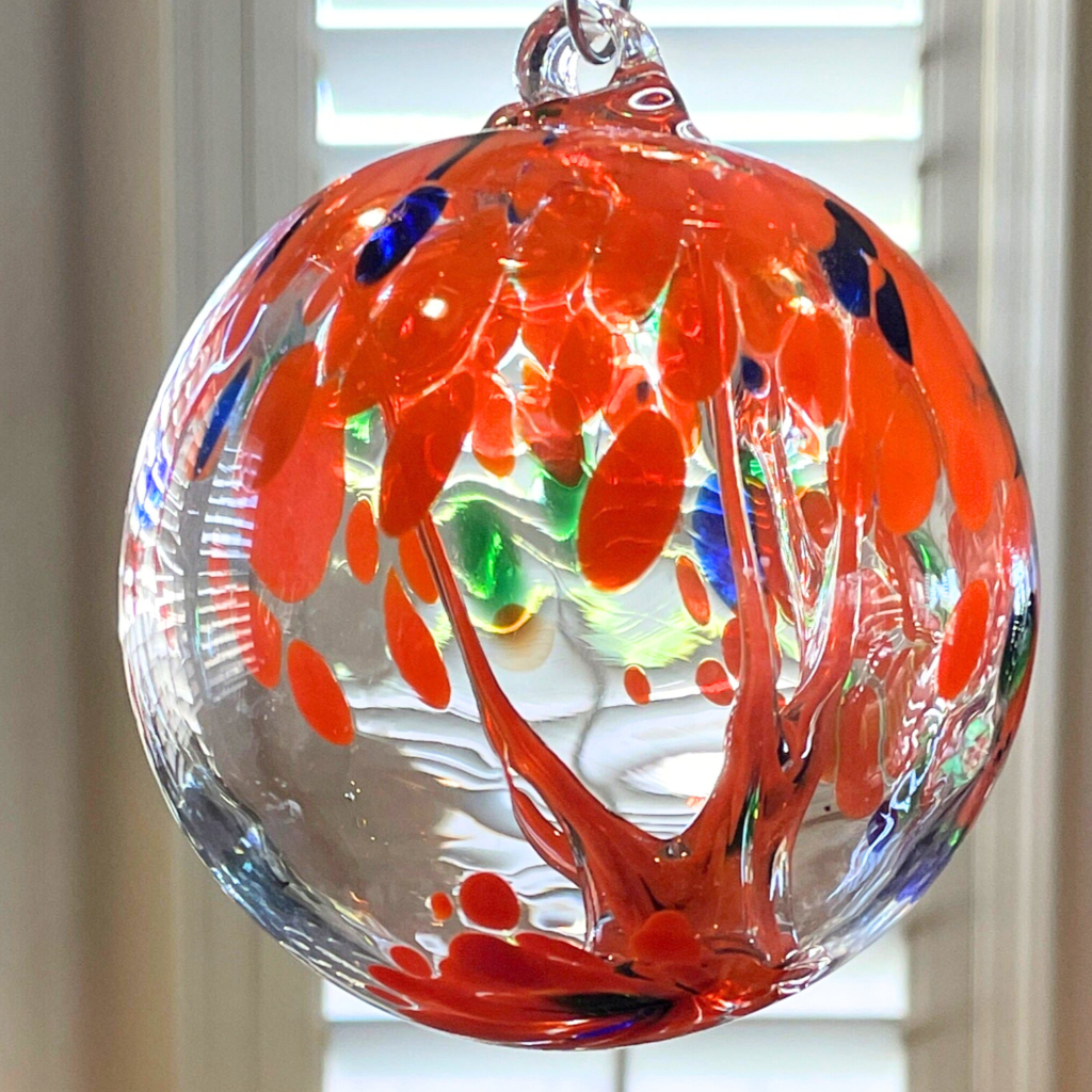 2 Sisters Artisan Glass blown glass witch ball with orange blue and green makes a pretty blown glass suncatcher.